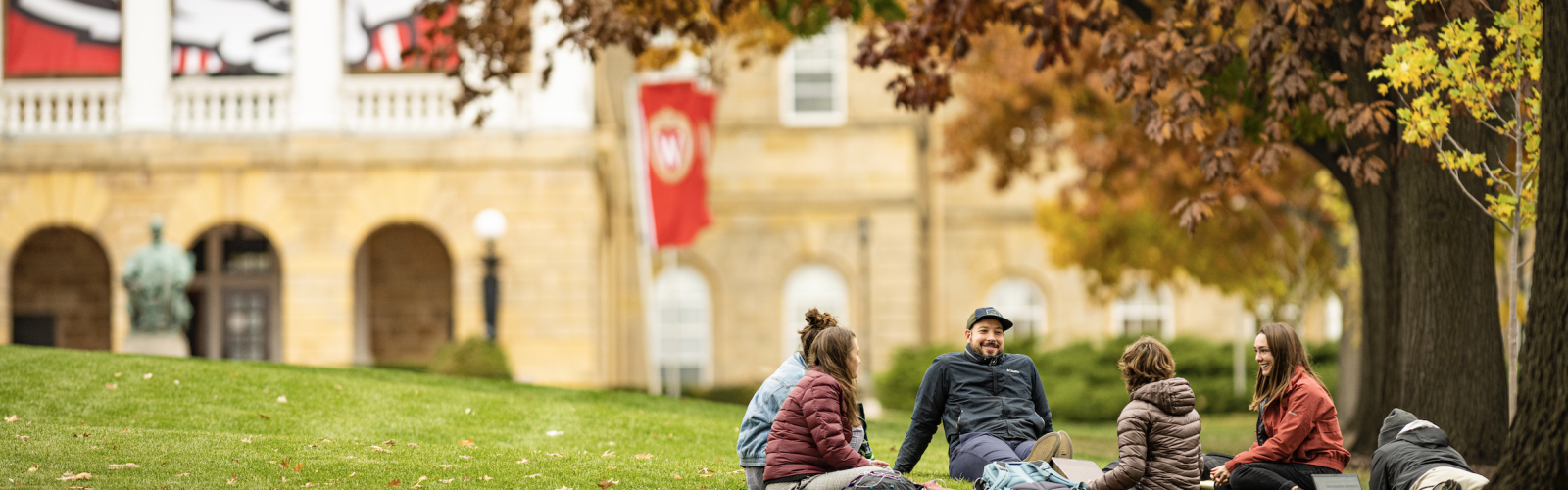 A group of masters students in the Nelson Institute Environmental Conservation program have an informal meeting outside on a warm day among the colors of the fall leaves on Bascom Hill at the University of Wisconsin-Madison during autumn on November 10, 2021. (Photo by Bryce Richter / UW-Madison)